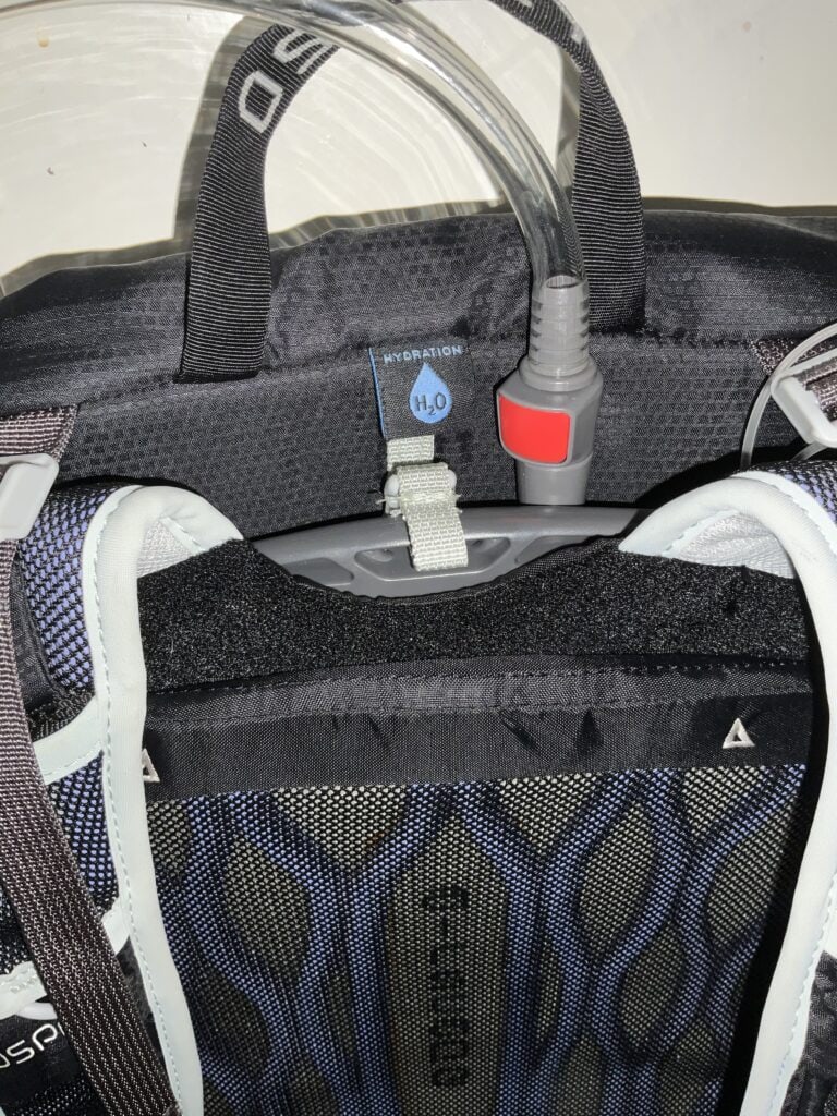 Osprey backpack showing the label for hydration bladder and clipped up hydration bladder