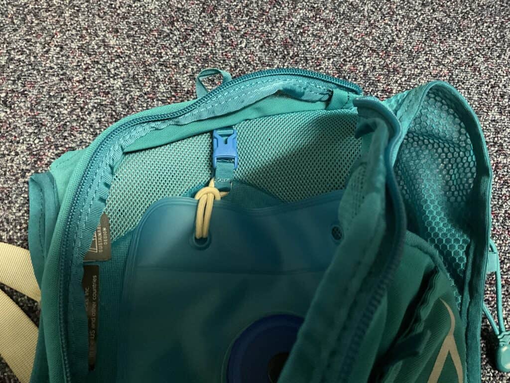 Blue osprey hydration pack with a different brand hydration bladder attached via hairband