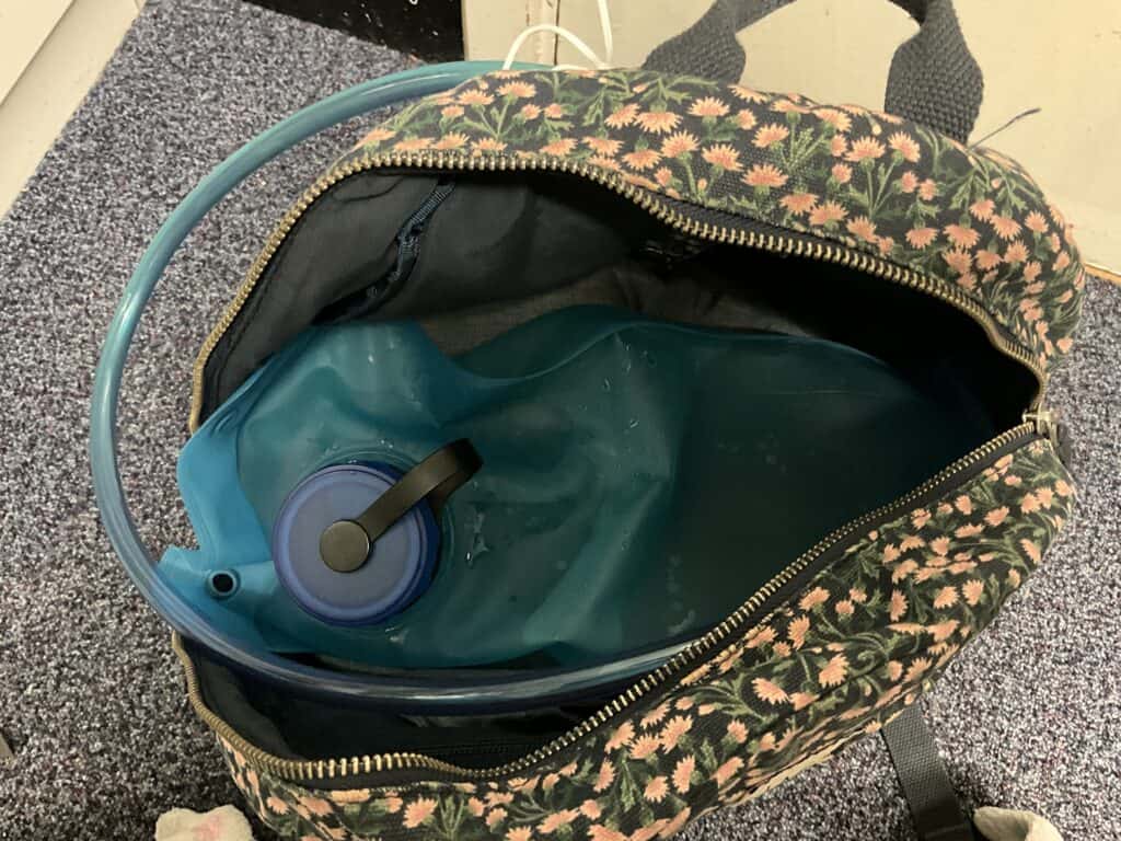 Hydration bladder lying flat on top of a backpack.